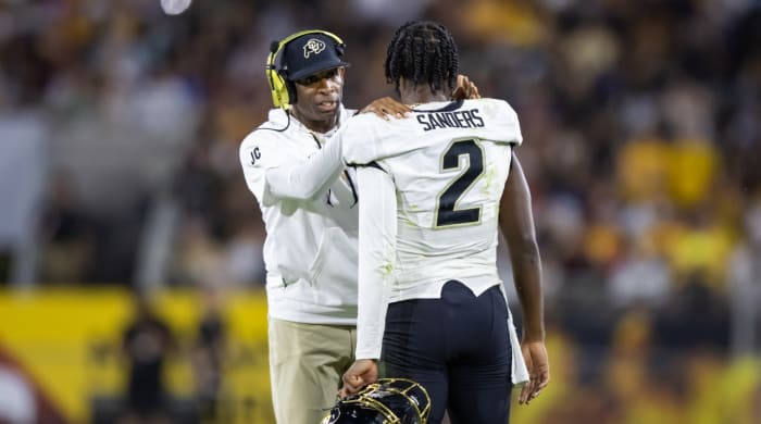 Deion Sanders speaks to his son, Colorado quarterback Shedeur Sanders during a game.